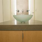 Glass vessel bowl, wall mount faucet and 6cm quartz countertops.